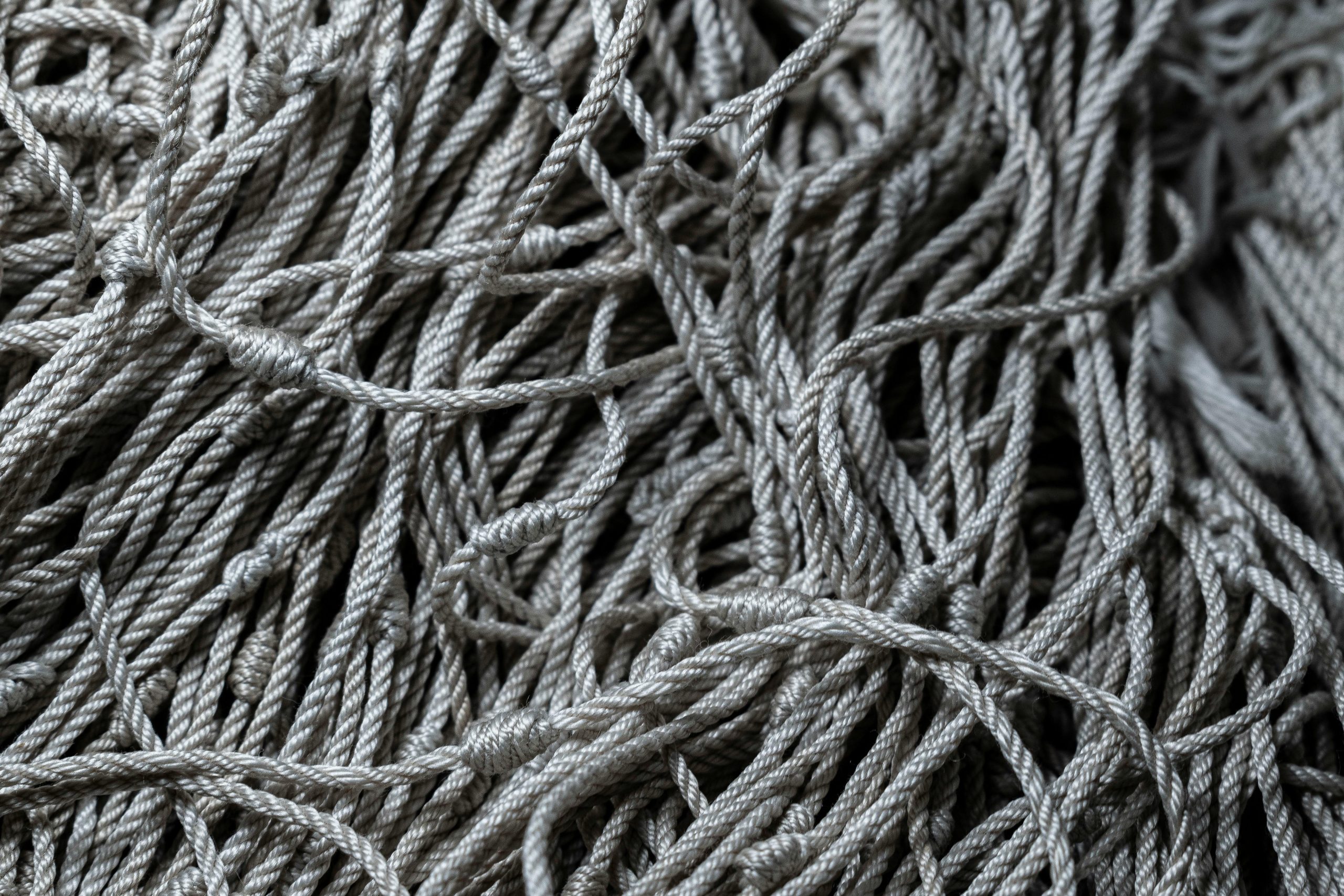 Detailed close-up of gray tangled ropes, perfect for textile and texture backgrounds.