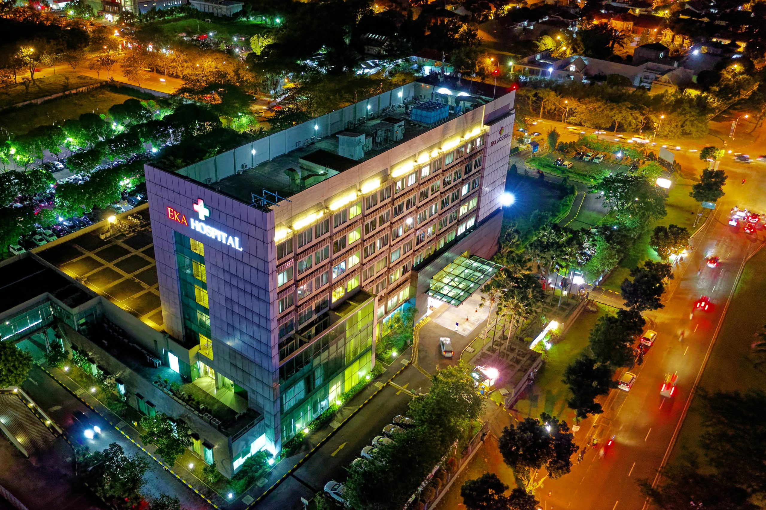 Stunning aerial view of Eka Hospital in Serpong, Indonesia, illuminated at night, capturing vibrant city lights and architecture.