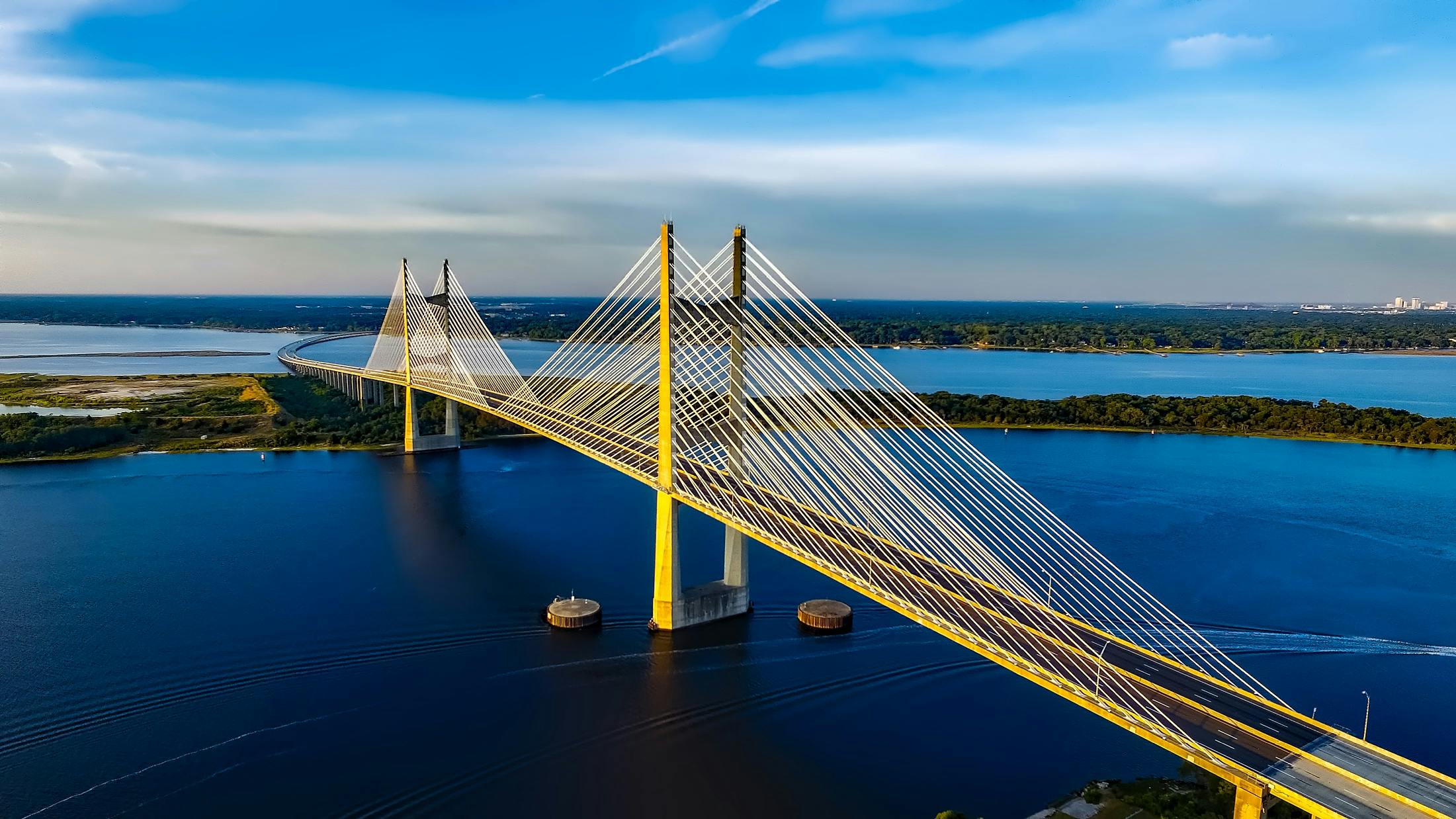 Stunning aerial shot of the Dames Point Bridge spanning over blue waters under a clear sky.