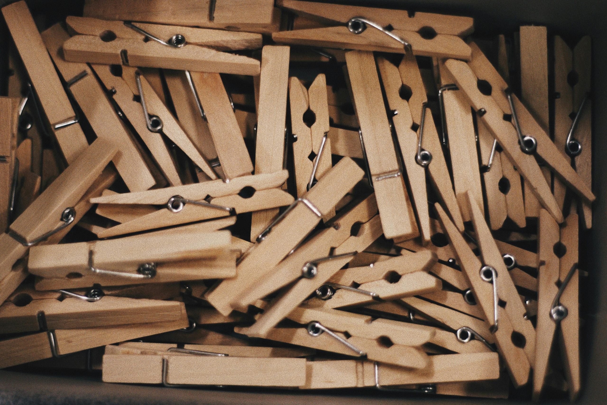 A detailed close-up of a collection of wooden clothespins in a box.