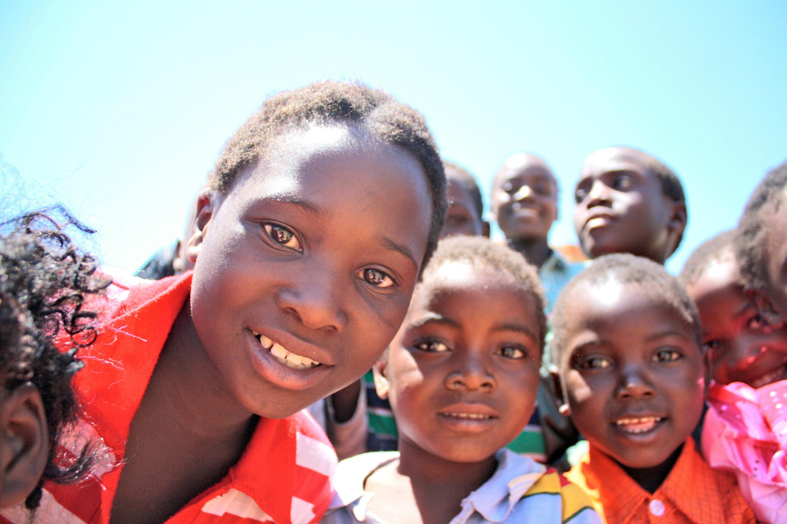 A vibrant portrait of children smiling and enjoying a sunny day outdoors