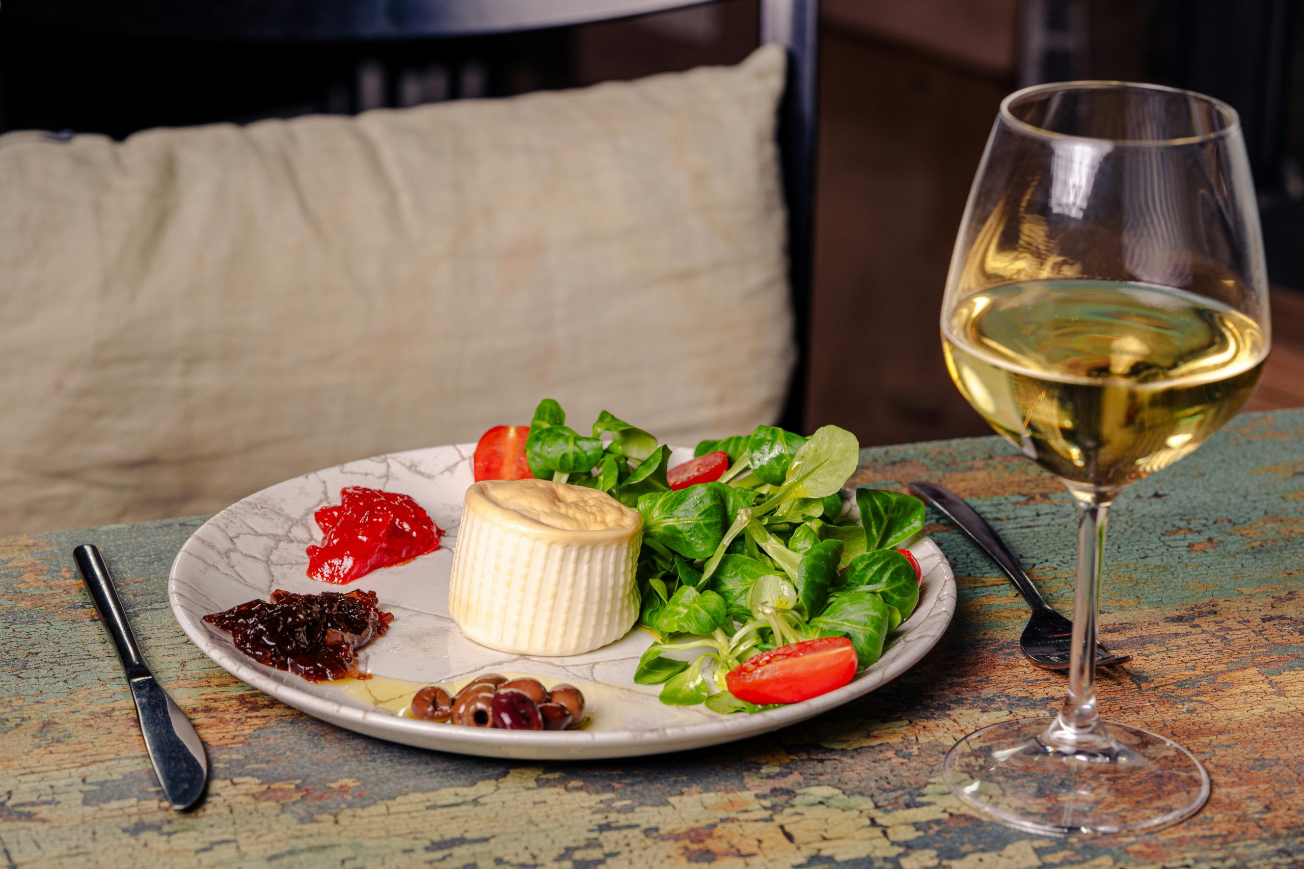 Delicious cheese platter with salad and wine. Perfect for dining imagery.