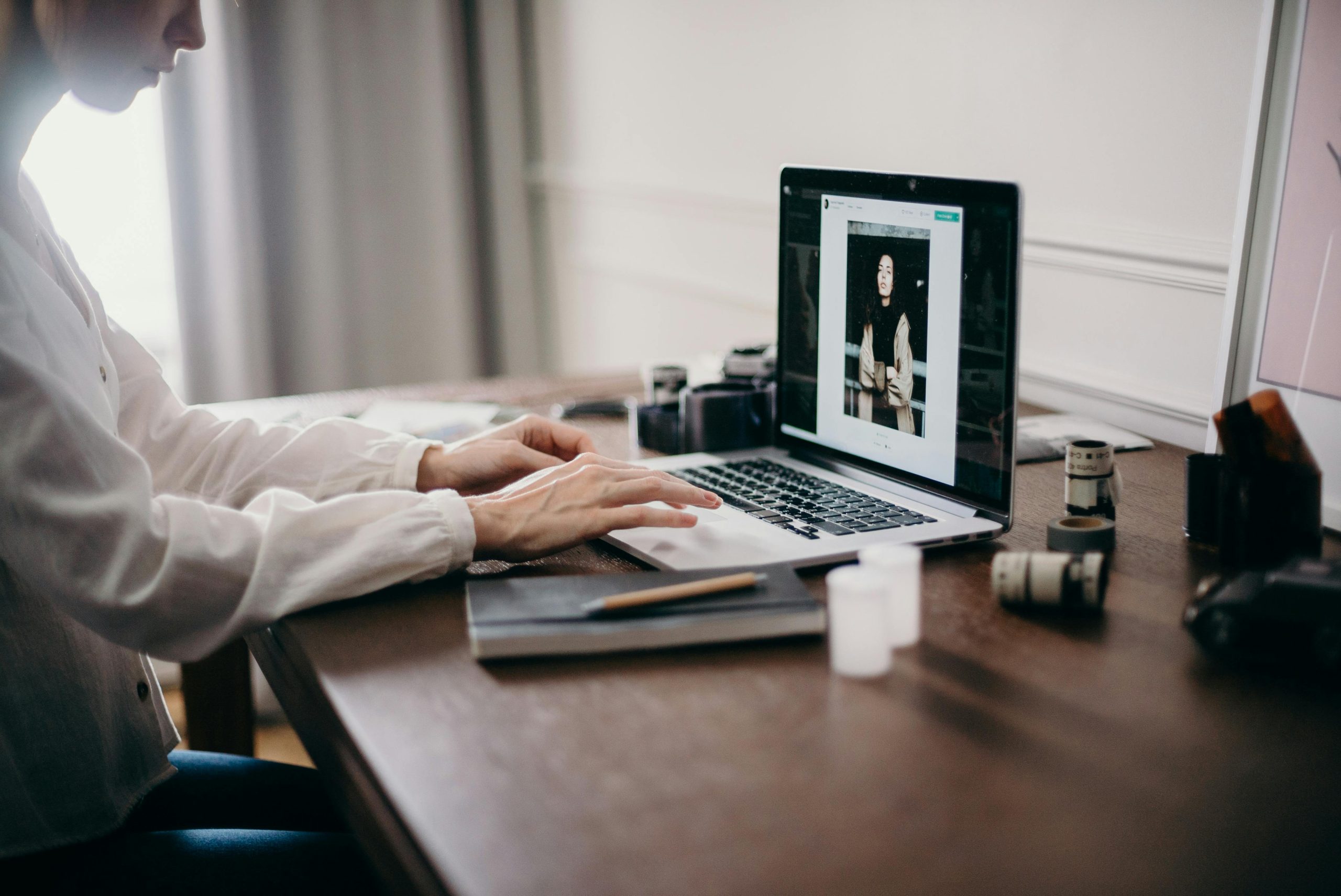 A freelancer working on a laptop in a cozy home office, focusing on creative design tasks.