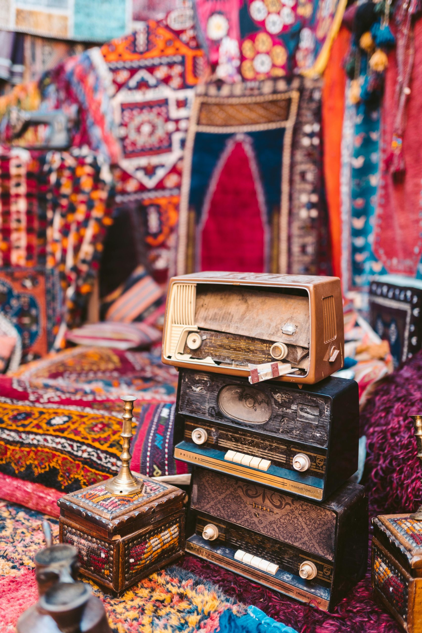 Vibrant display of traditional Turkish carpets and vintage radios in a bustling bazaar.