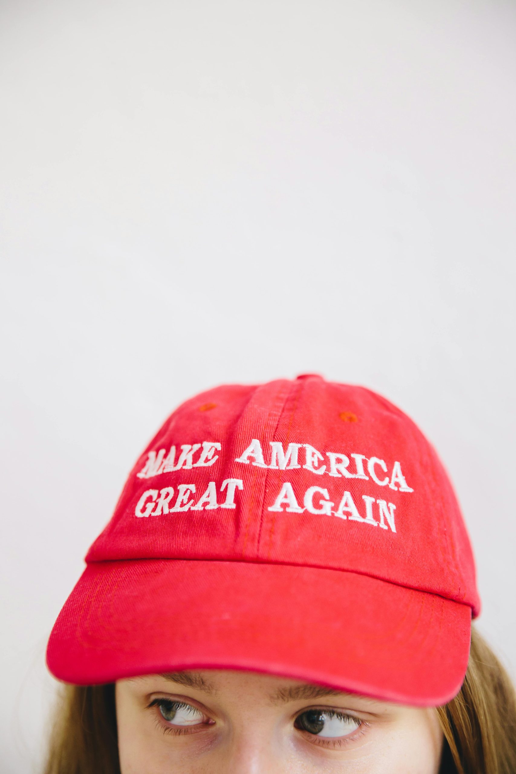 Close-up of a red 'Make America Great Again' cap on a person's head.