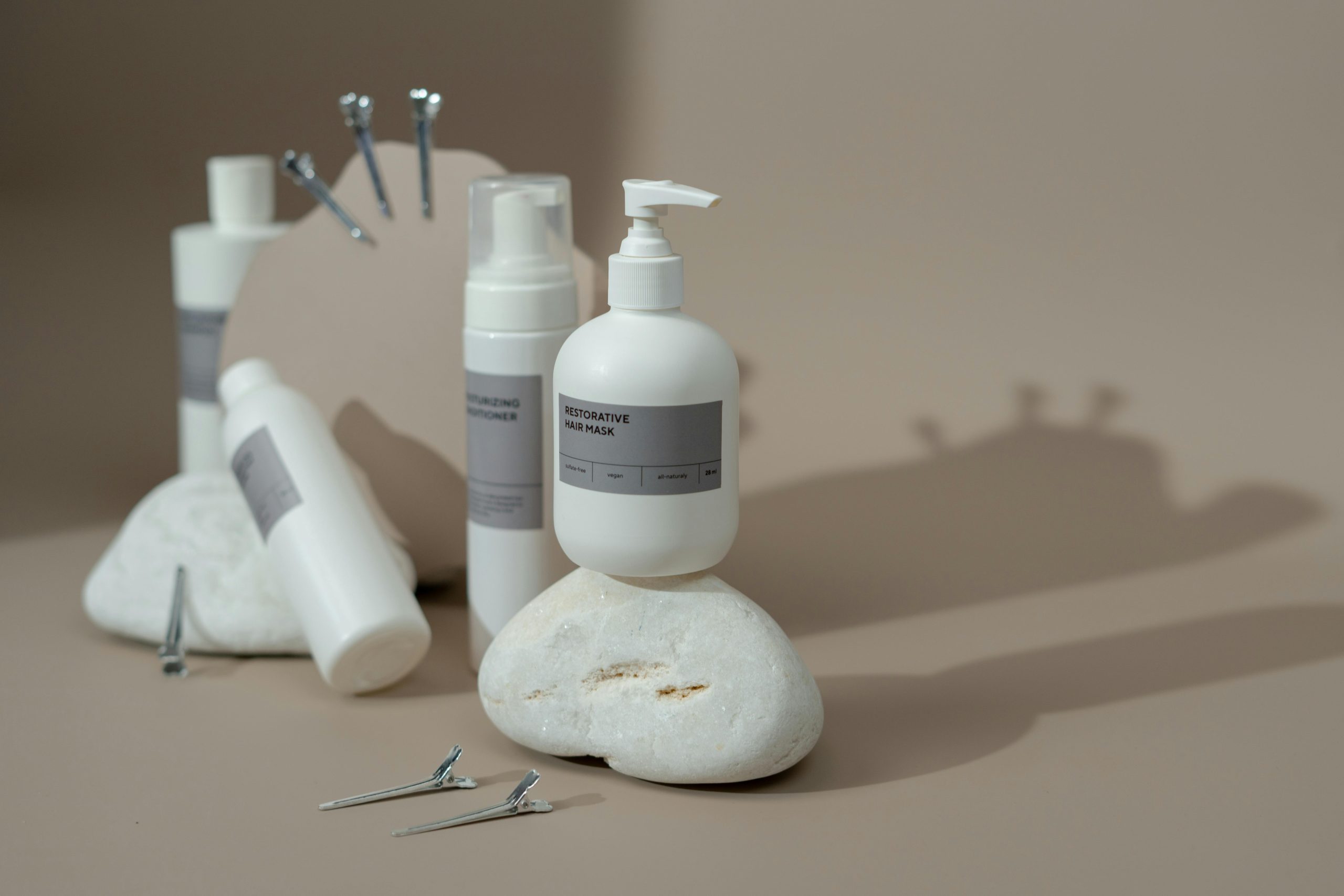 Stylish display of haircare products including shampoo and conditioner bottles on a minimalist set with neutral tones.