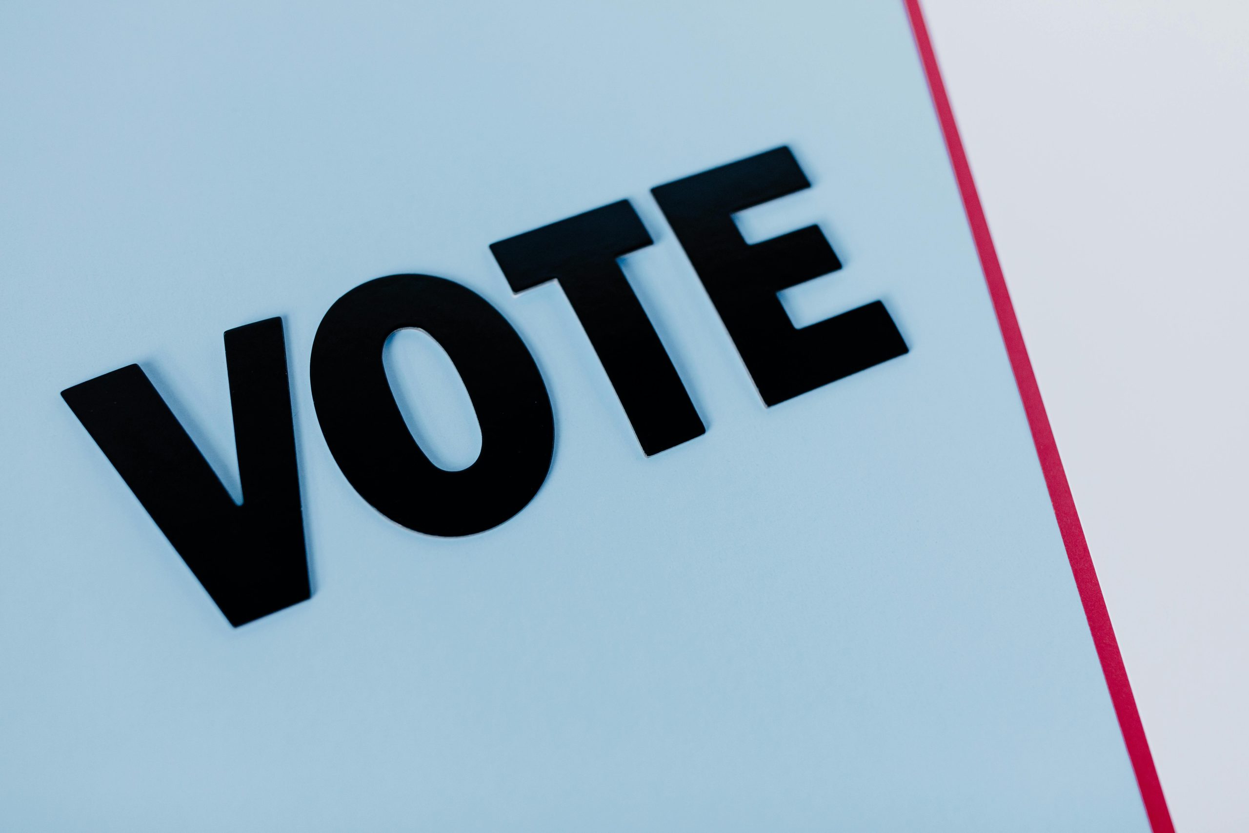 Close-up of the word 'VOTE' on a minimal background, emphasizing voting importance.