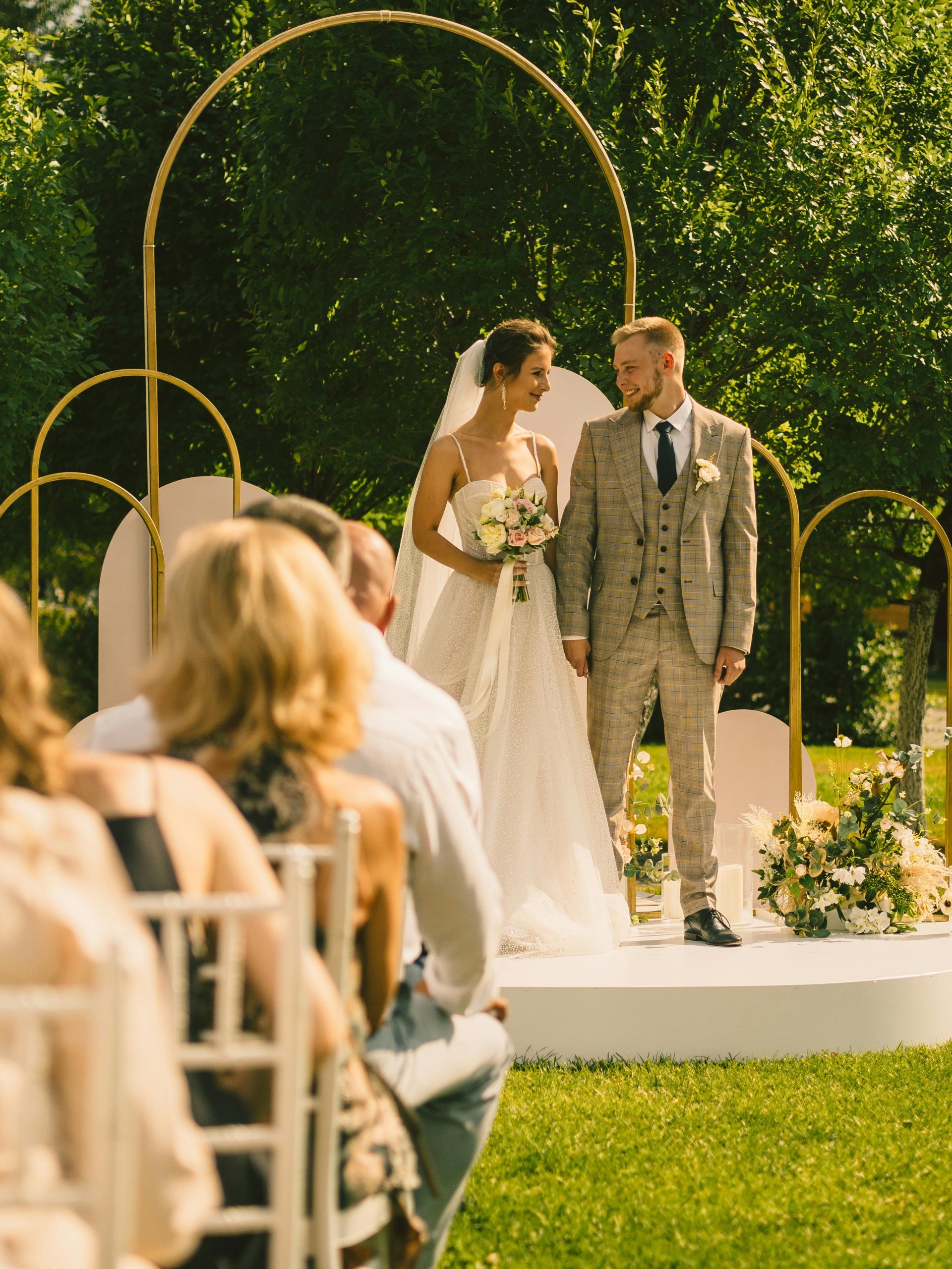 Bride and groom share a tender moment in a scenic outdoor wedding ceremony.